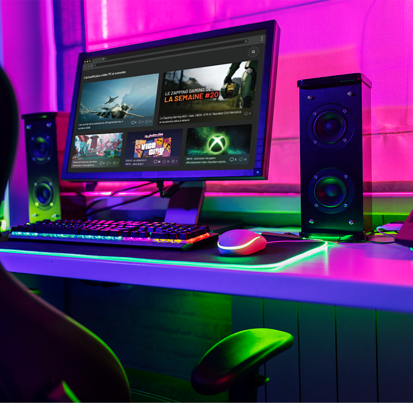 Espace gaming éclairé en rose et vert pour l'article sur les jeux et mises à jour à surveiller